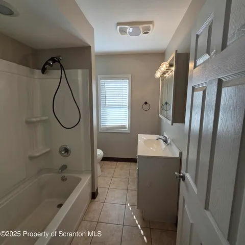 a bathroom with a bath tub a mirror and a shower