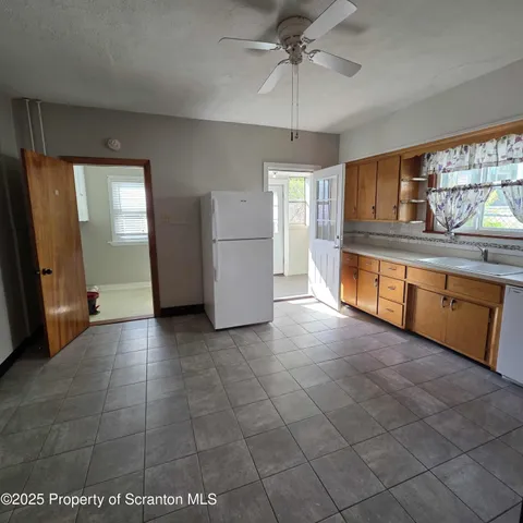a view of a kitchen with a sink and a refrigerator