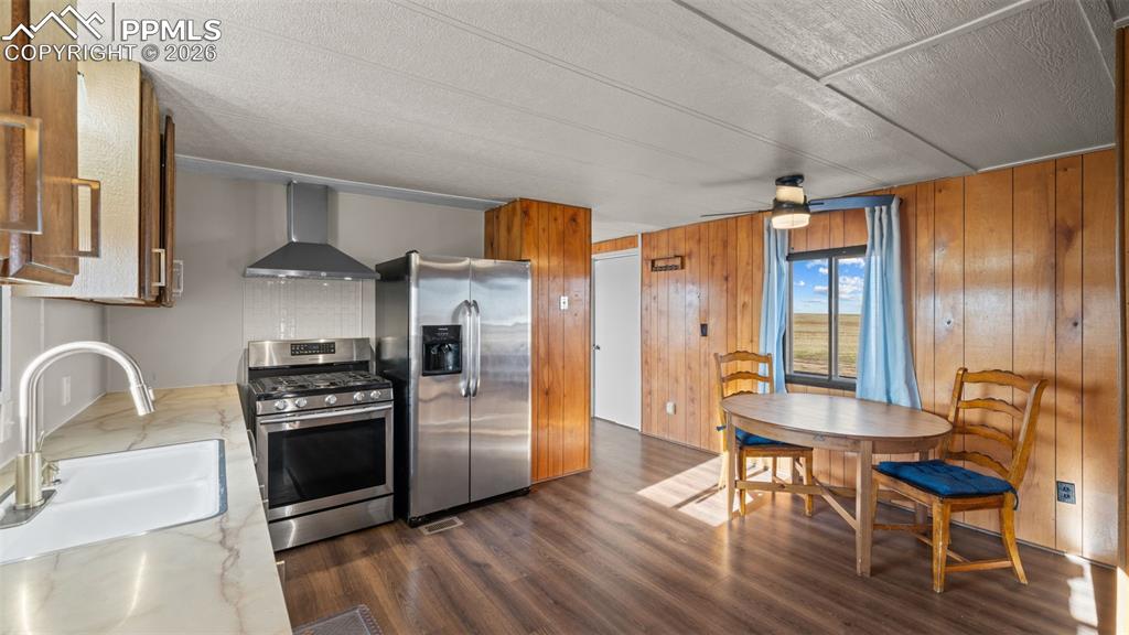 37155 East Jones Road Yoder, CO 80864 - Photo 34 of 50 a kitchen with granite countertop a stove a refrigerator and wooden floor