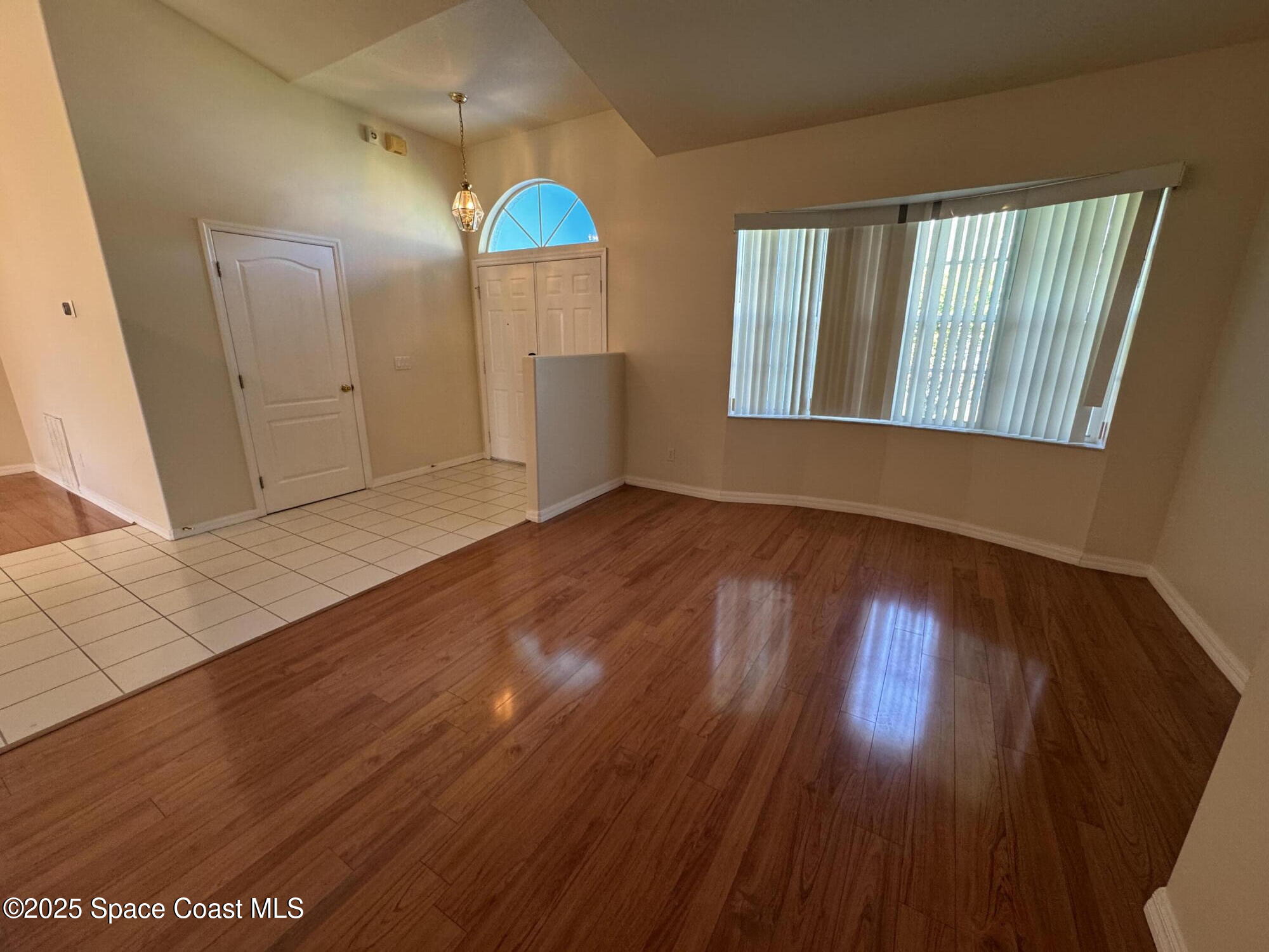 1522 Breese Street Northeast Palm Bay, FL 32905 - Photo 4 of 12 an empty room with wooden floor and windows