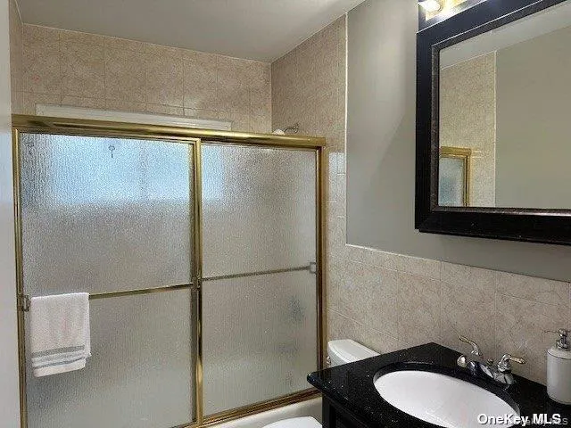 a bathroom with a granite countertop sink mirror and toilet