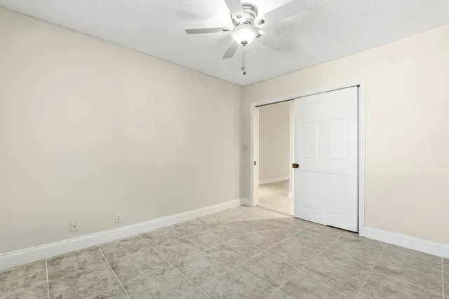 an empty room with windows and closet