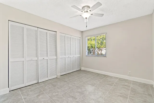 an empty room with a ceiling fan and carpet