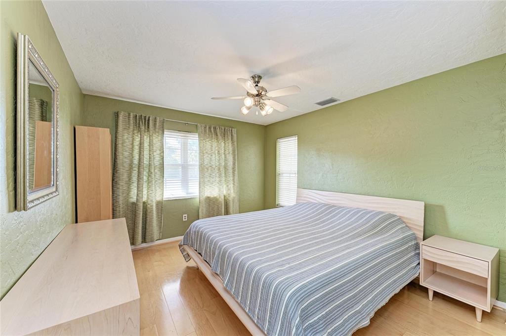 612 Bayshore Road Nokomis, FL 34275 - Photo 29 of 96 a bedroom with a large bed and a chandelier