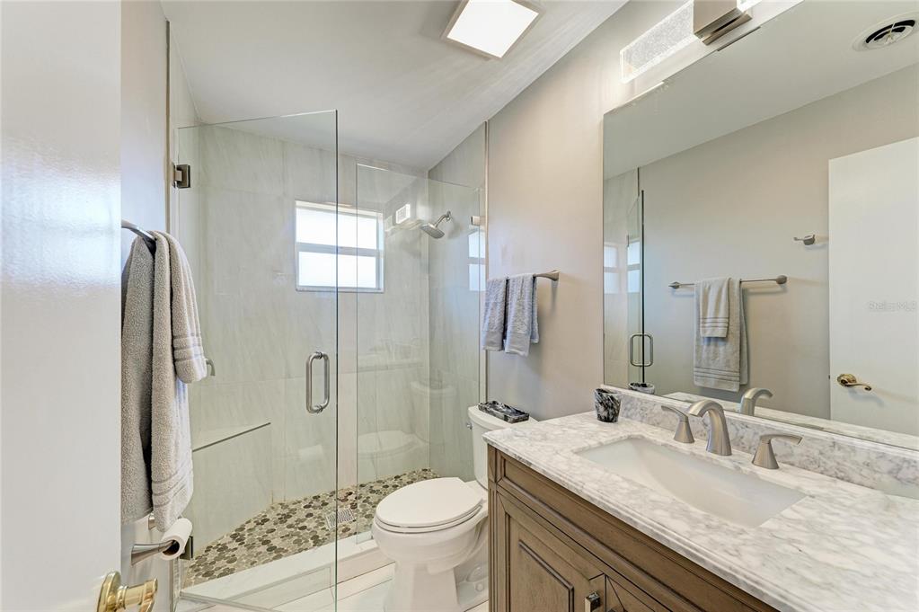612 Bayshore Road Nokomis, FL 34275 - Photo 31 of 96 a bathroom with a granite countertop sink toilet mirror and shower
