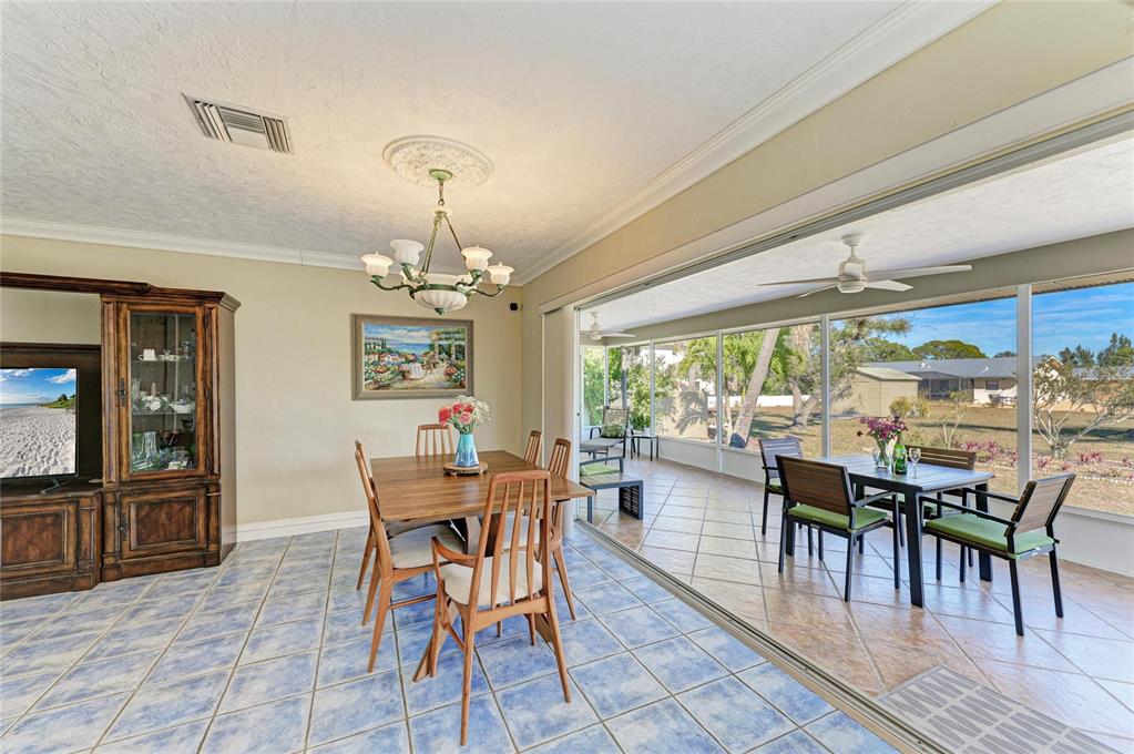 612 Bayshore Road Nokomis, FL 34275 - Photo 35 of 96 a dining room with furniture a chandelier and wooden floor