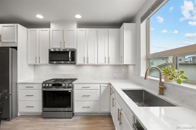 a kitchen with stainless steel appliances granite countertop a sink dishwasher a stove and a microwave oven with cabinets