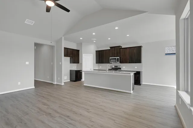 a view of kitchen with microwave oven stove and white cabinets