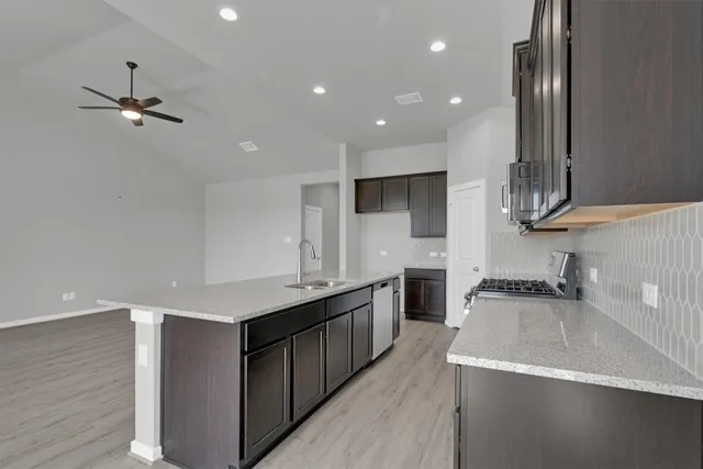 a kitchen with kitchen island a sink stainless steel appliances and cabinets