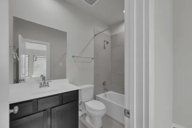 a bathroom with a sink a toilet a mirror and shower