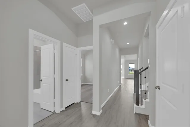 a view of hallway with stairs and wooden floor