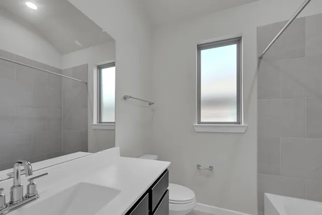 a bathroom with a sink toilet vanity and tub