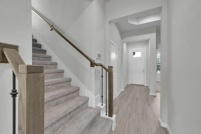 a view of a hallway with wooden floor and entryway