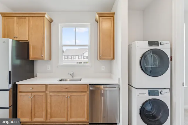 a kitchen with stainless steel appliances white cabinets sink and window