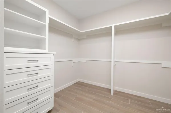 an empty room with a window and wooden floor