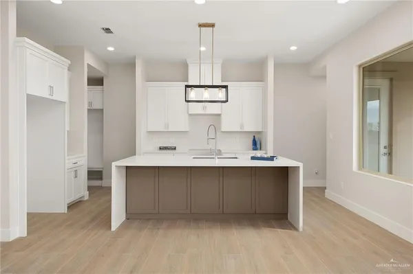 a kitchen with kitchen island a sink stainless steel appliances and cabinets
