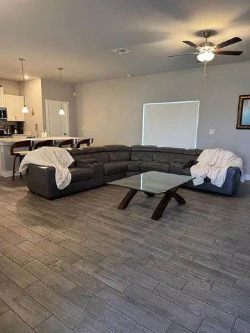 a living room with furniture and a wooden floor