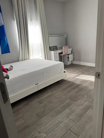 a bed sitting in a bedroom next to a window