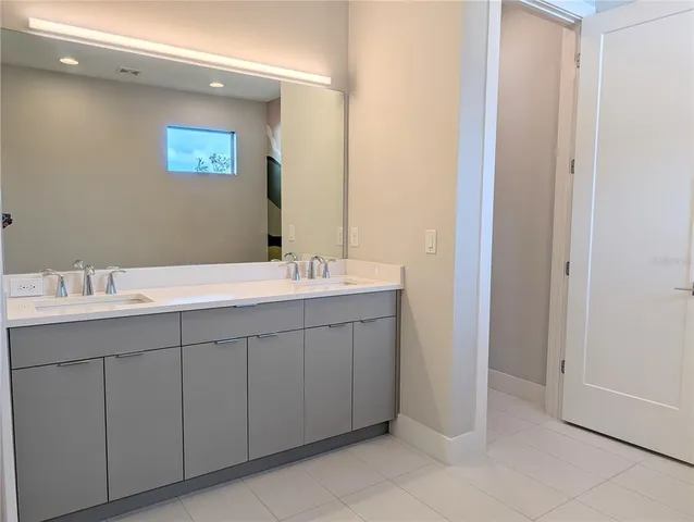 a bathroom with a double vanity sink and a mirror