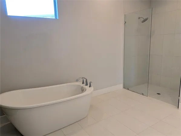 a white bath tub sitting next to a shower