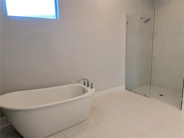 a white bath tub sitting next to a shower