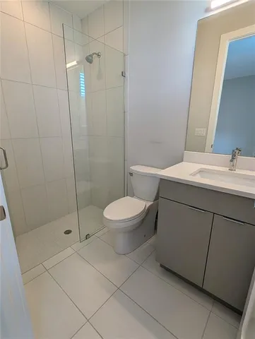 a bathroom with a toilet a sink a shower and mirror