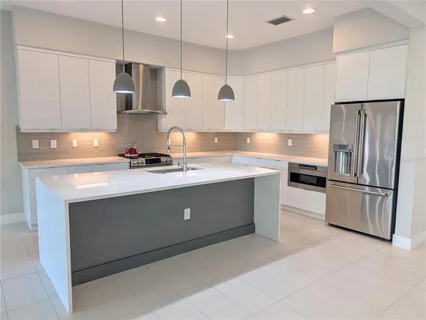 a kitchen with stainless steel appliances a refrigerator sink and microwave