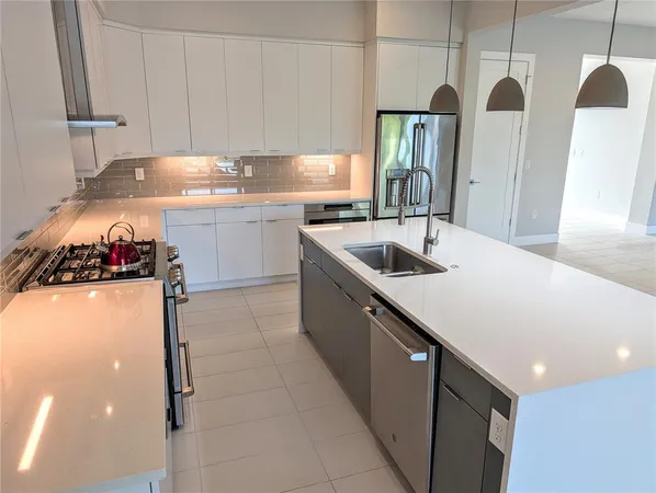 a kitchen with stainless steel appliances granite countertop a sink and a refrigerator