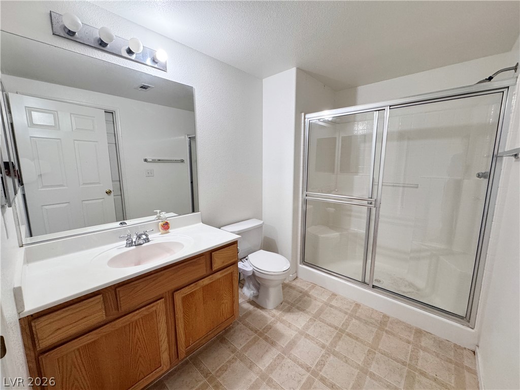 9580 West Reno Avenue, Unit 242 Las Vegas, NV 89148 - Photo 17 of 26 A well-lit bathroom features a spacious shower stall and a single vanity with ample counter space.