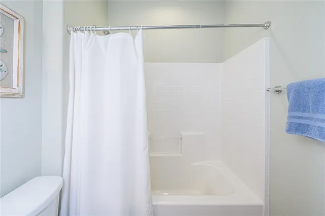 a bathroom with a shower curtain and toilet