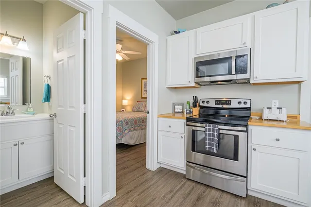 a kitchen with white cabinets and stainless steel appliances