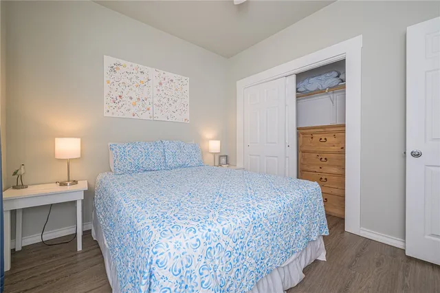 a bedroom with a bed and a lamp on dresser