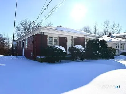 a front view of a house with yard and a garden