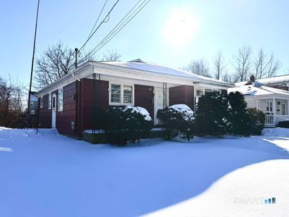 a front view of a house with yard and a garden