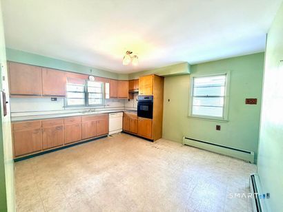 282 Horace Street Bridgeport, CT 06610 - Photo 5 of 16 a kitchen with stainless steel appliances granite countertop a refrigerator and a stove top oven