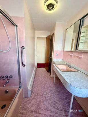 282 Horace Street Bridgeport, CT 06610 - Photo 6 of 16 a bathroom with a tub a sink and a large mirror