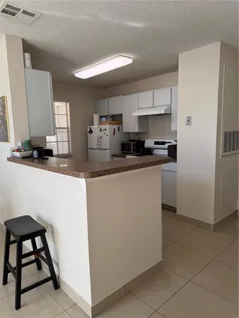 a kitchen with stainless steel appliances granite countertop a sink a stove a refrigerator a microwave a counter top and cabinets