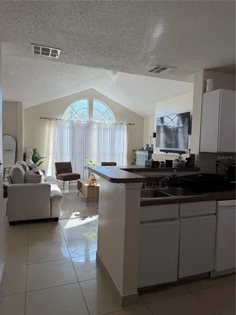 a kitchen with kitchen island granite countertop a sink and a white cabinets