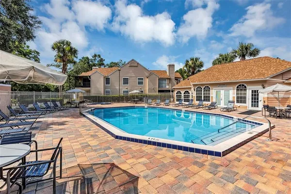 a view of a house with pool and chairs