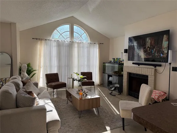 a living room with furniture a fireplace and a flat screen tv
