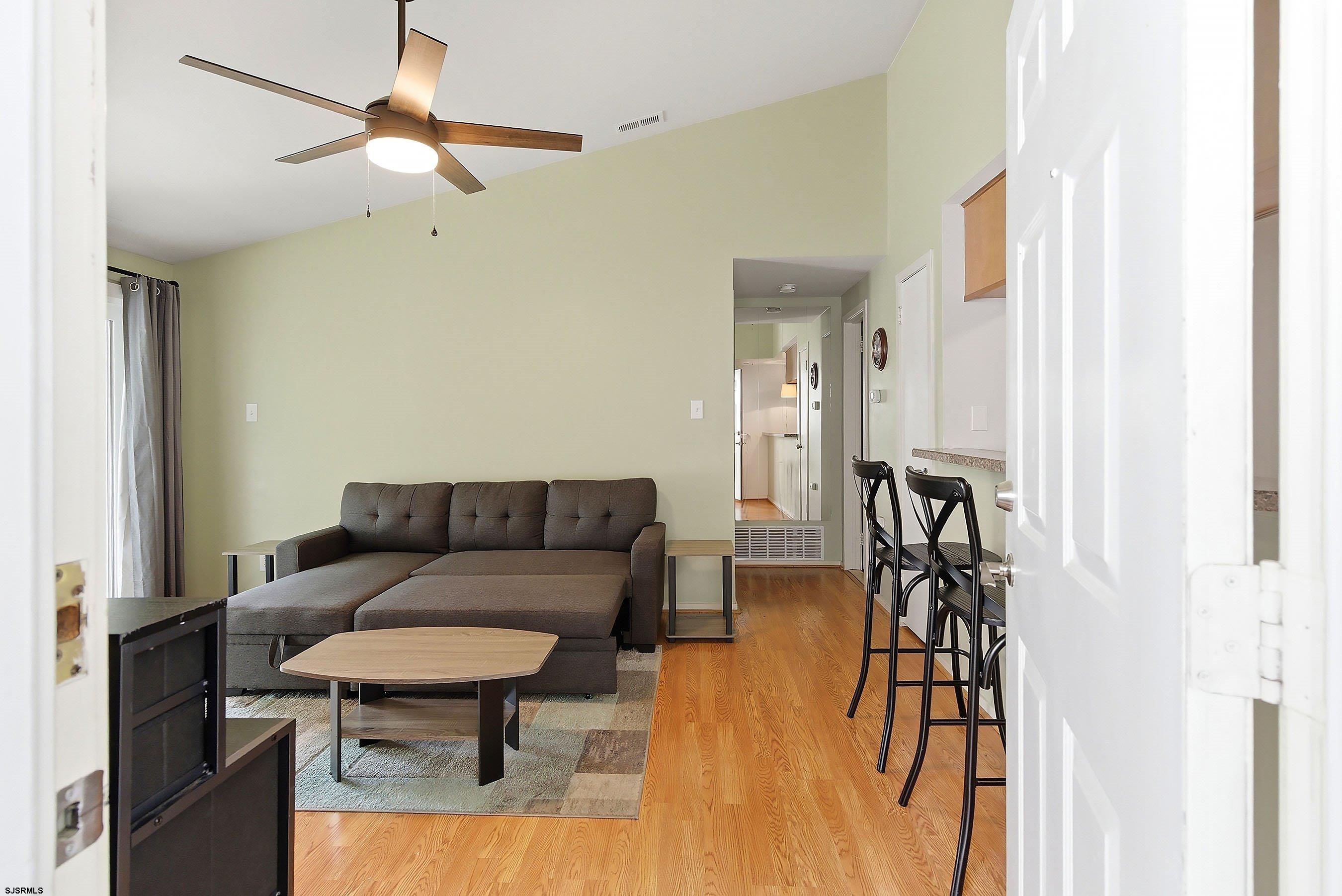 224 Meadow Ridge Road, Unit 224 Smithville, NJ 08205 - Photo 5 of 22 a living room with furniture and a chandelier