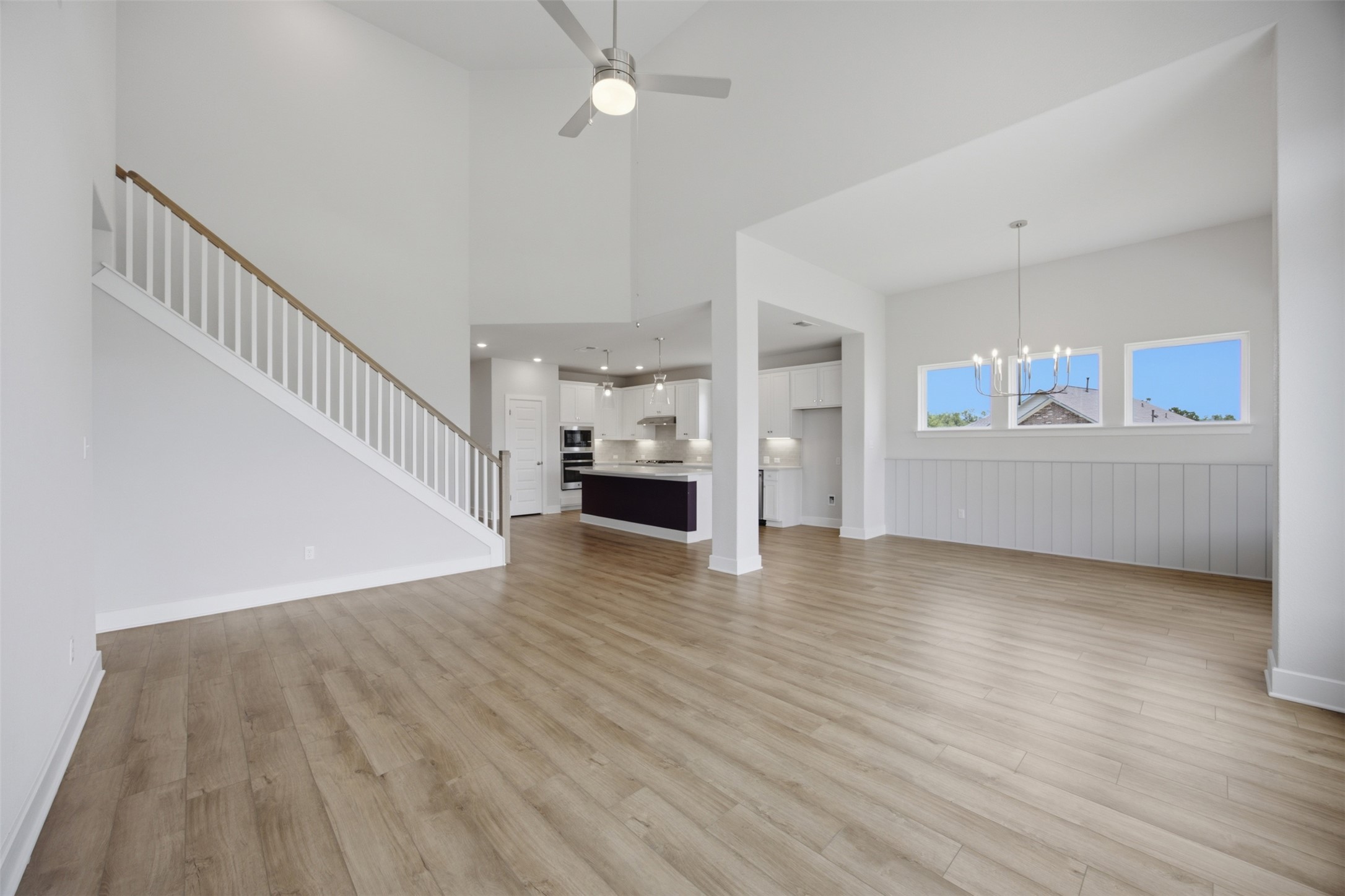 2101 Little Snake Way Georgetown, TX 78633 - Photo 17 of 37 An airy living space features soaring vaulted ceilings, natural light, and seamless flow into a modern kitchen.
