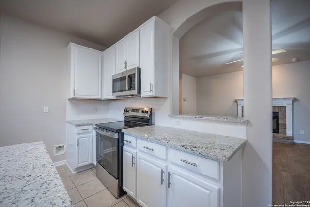 a kitchen with stainless steel appliances granite countertop a stove a sink and a microwave