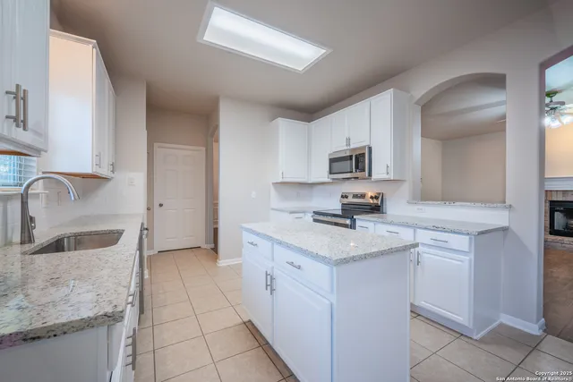 a kitchen with a sink dishwasher stove and cabinets
