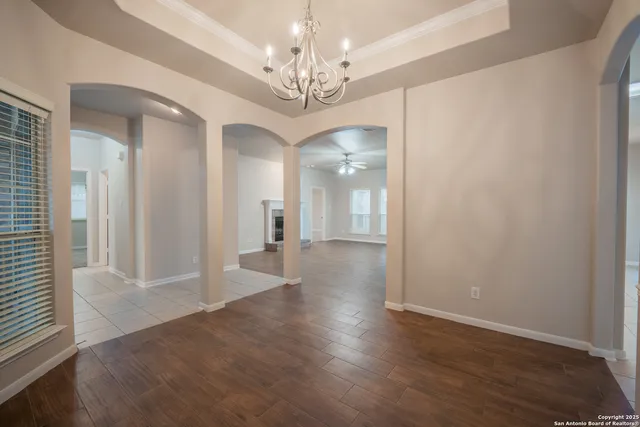 a view of a hallway with wooden floor and a chandelier