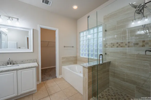 a spacious bathroom with a bathtub sink and mirror