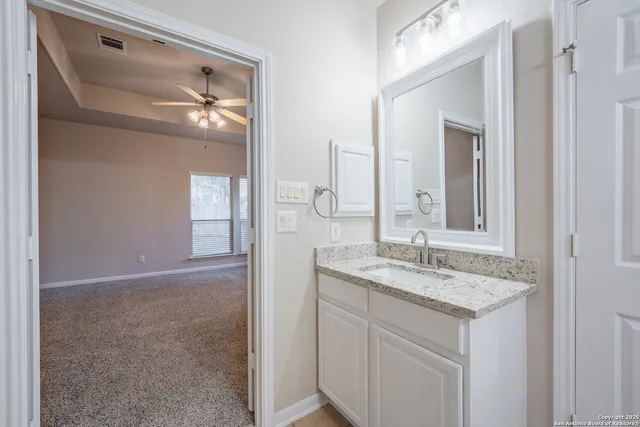 a bathroom with a granite countertop sink and a mirror