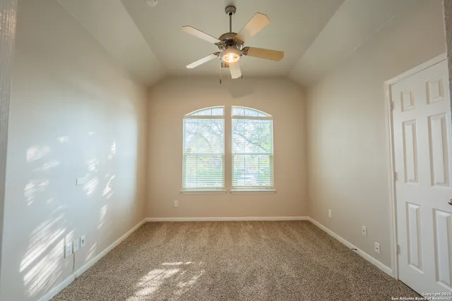 en empty room with windows and ceiling fan
