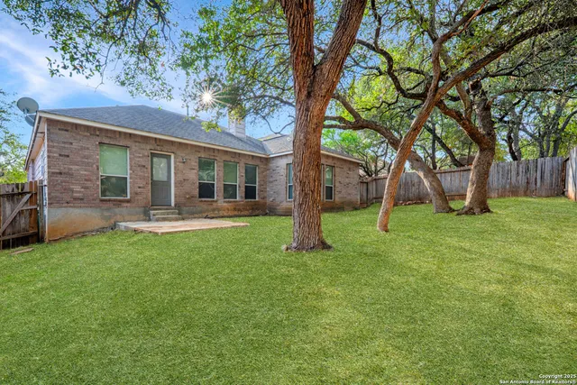 a view of a house with backyard and a tree