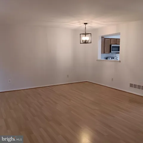 an empty room with a wooden floor and a ceiling fan